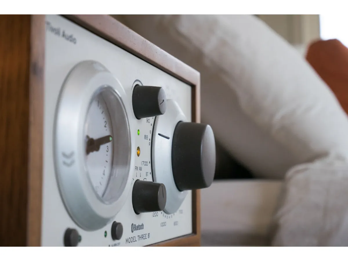 A close-up view of stylish audio equipment, with tactile control knobs and a prominent gauge—evoking a sense of vintage charm. The space feels cozy and inviting, perfect for relaxing or setting the mood with music.